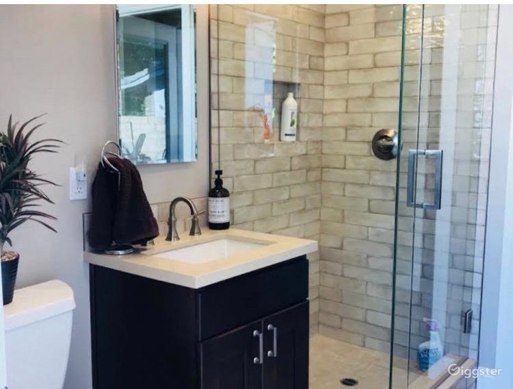 Modern bathroom featuring glass-enclosed walk-in shower with subway tile