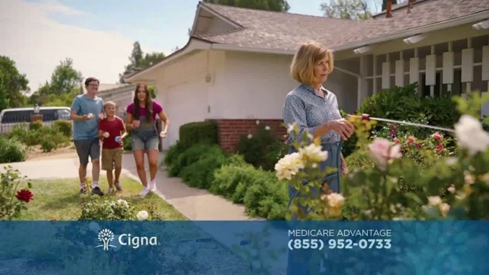Cigna Medicare commercial front yard scene showing cast walking up the rose-lined path to the home