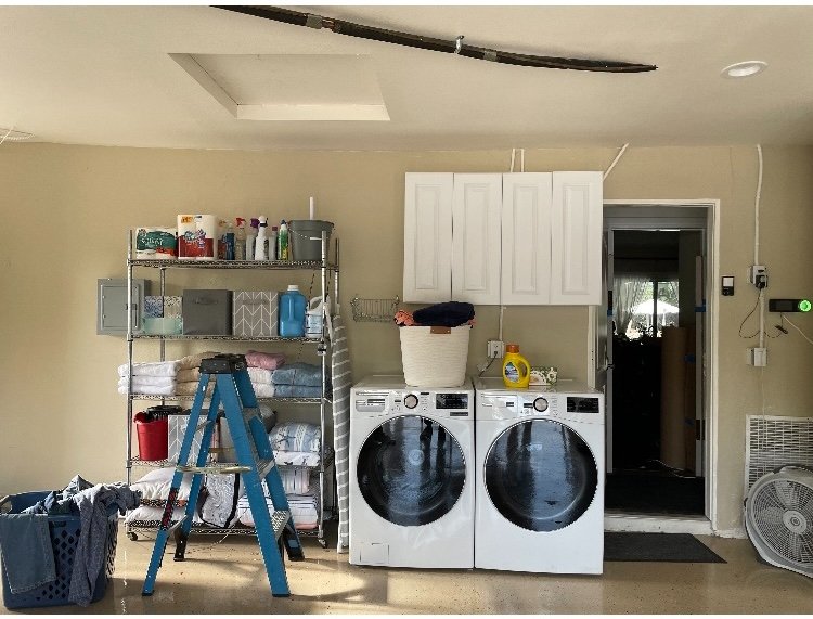 Laundry area in garage with washer and dryer and built-in cabinetry