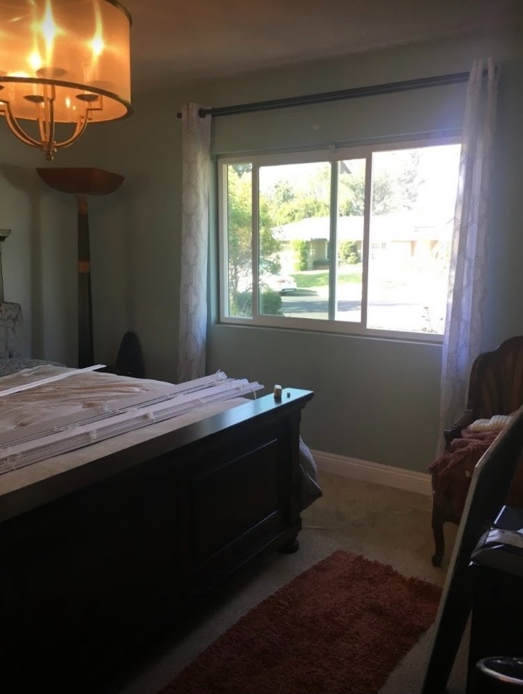 Master bedroom side view showing large windows with natural light and chandelier