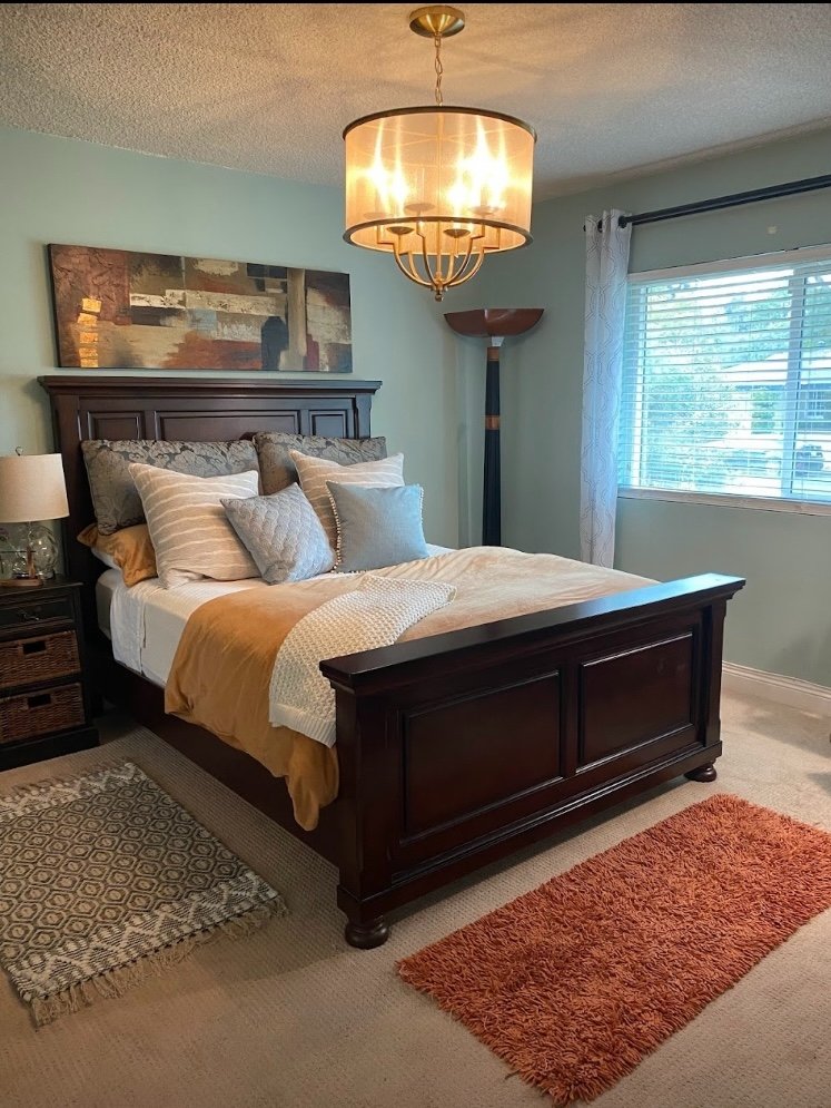 Close view of master bedroom with dark wood bed and chandelier