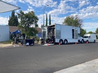 Multiple grip and equipment trucks lined up on the street during production